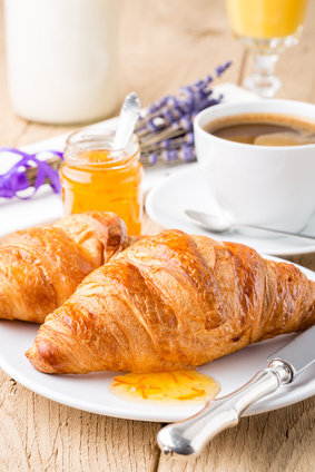 Croissants with orange jam and coffee. Shallow depth of field.